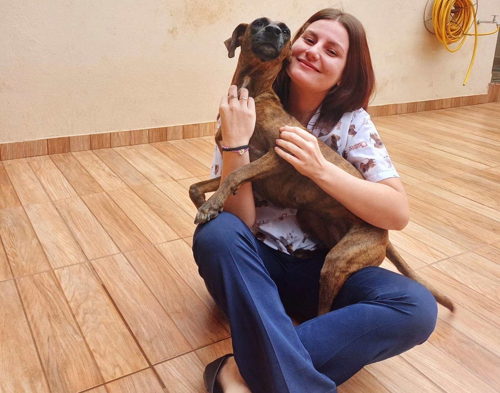 Dra. Leticia Alves abraçando um cão caramelo com muito afeto