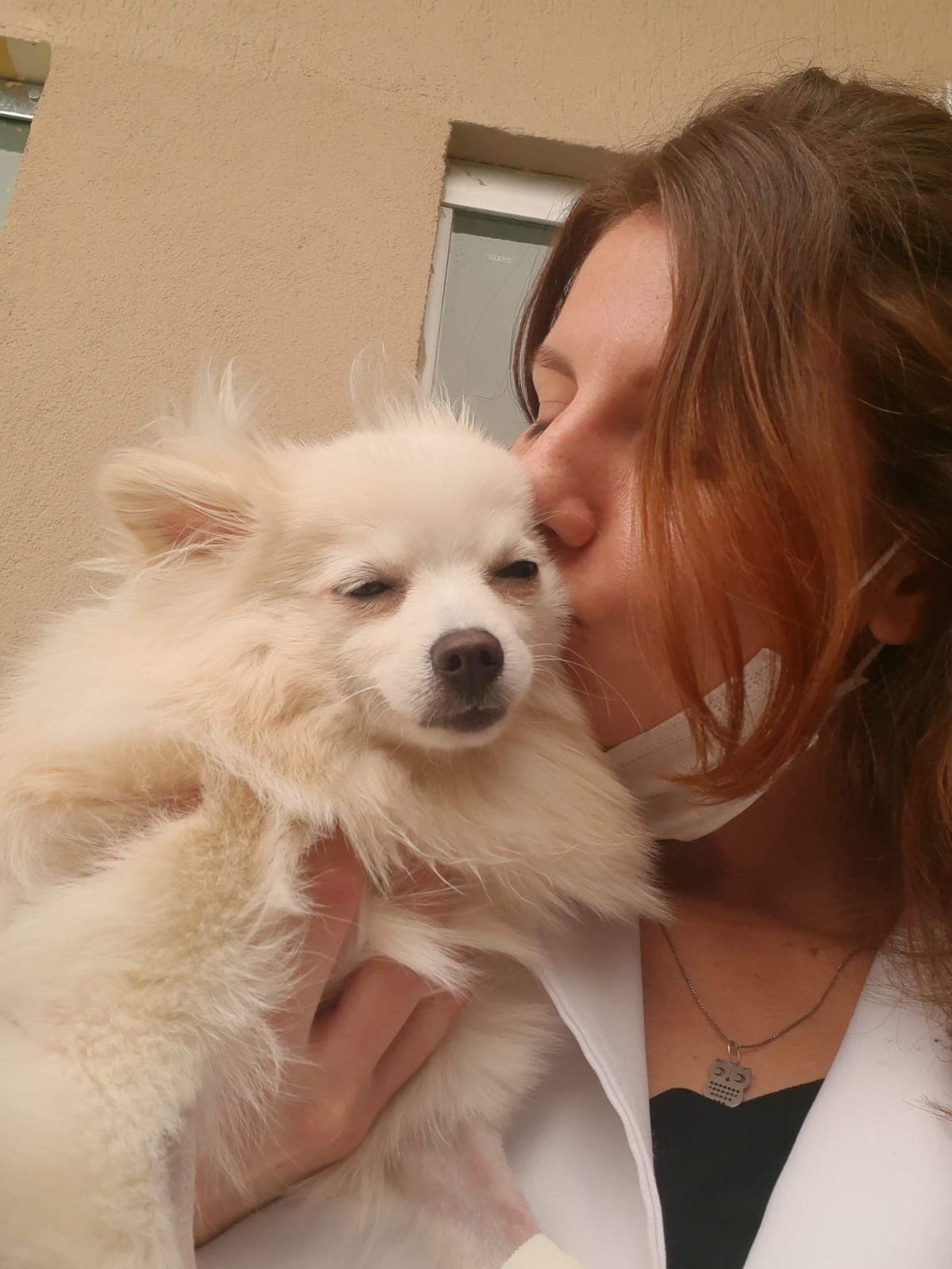 Dra. Leticia Alves demonstrando afeto a um pequeno lulu da pomerânia